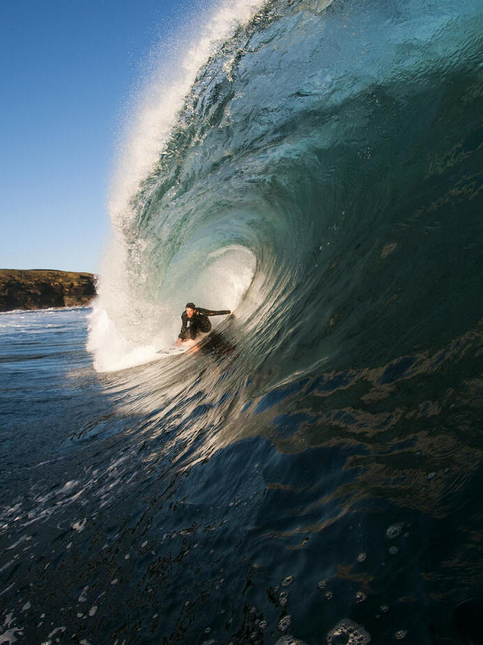 Homme surfant sur une vague géante dans la mer