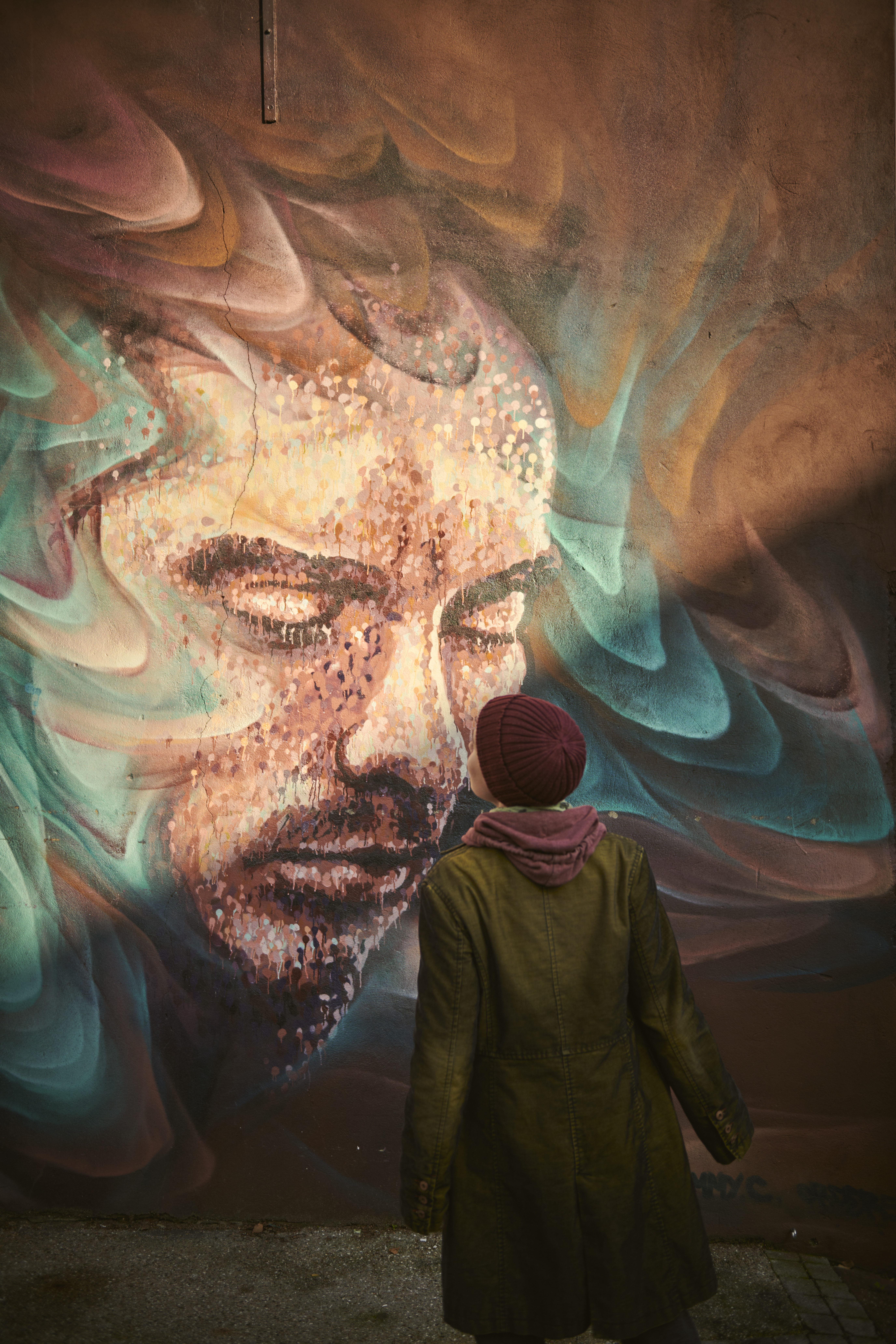 Woman standing looking at street art mural