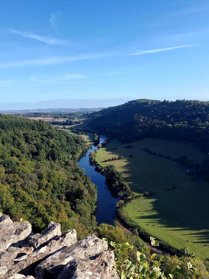 A rocky outlook surrounded by trees with a river below.