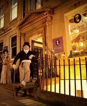 Zwei Personen in historischen Kostümen vor einem viktorianischen Museum.