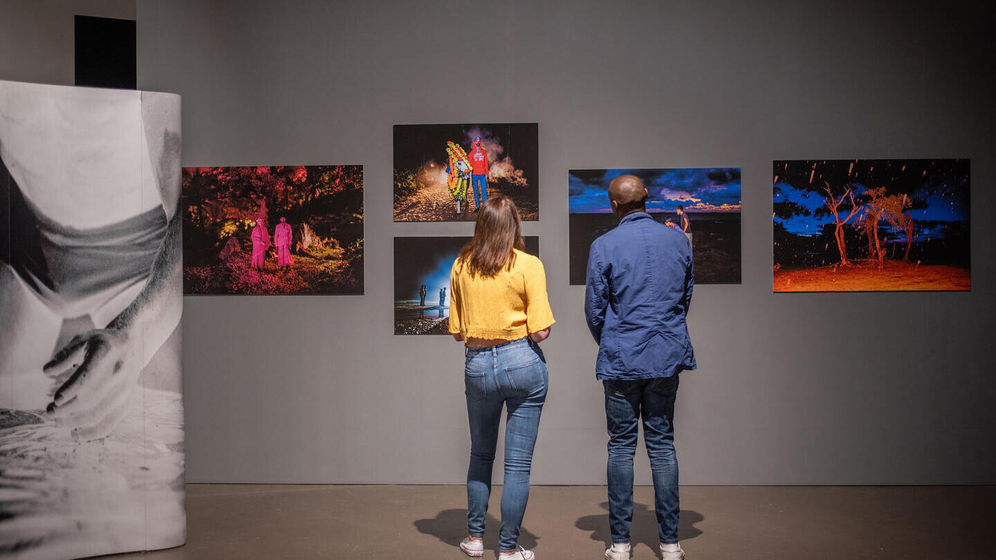A woman and a man stand looking at an exhibition