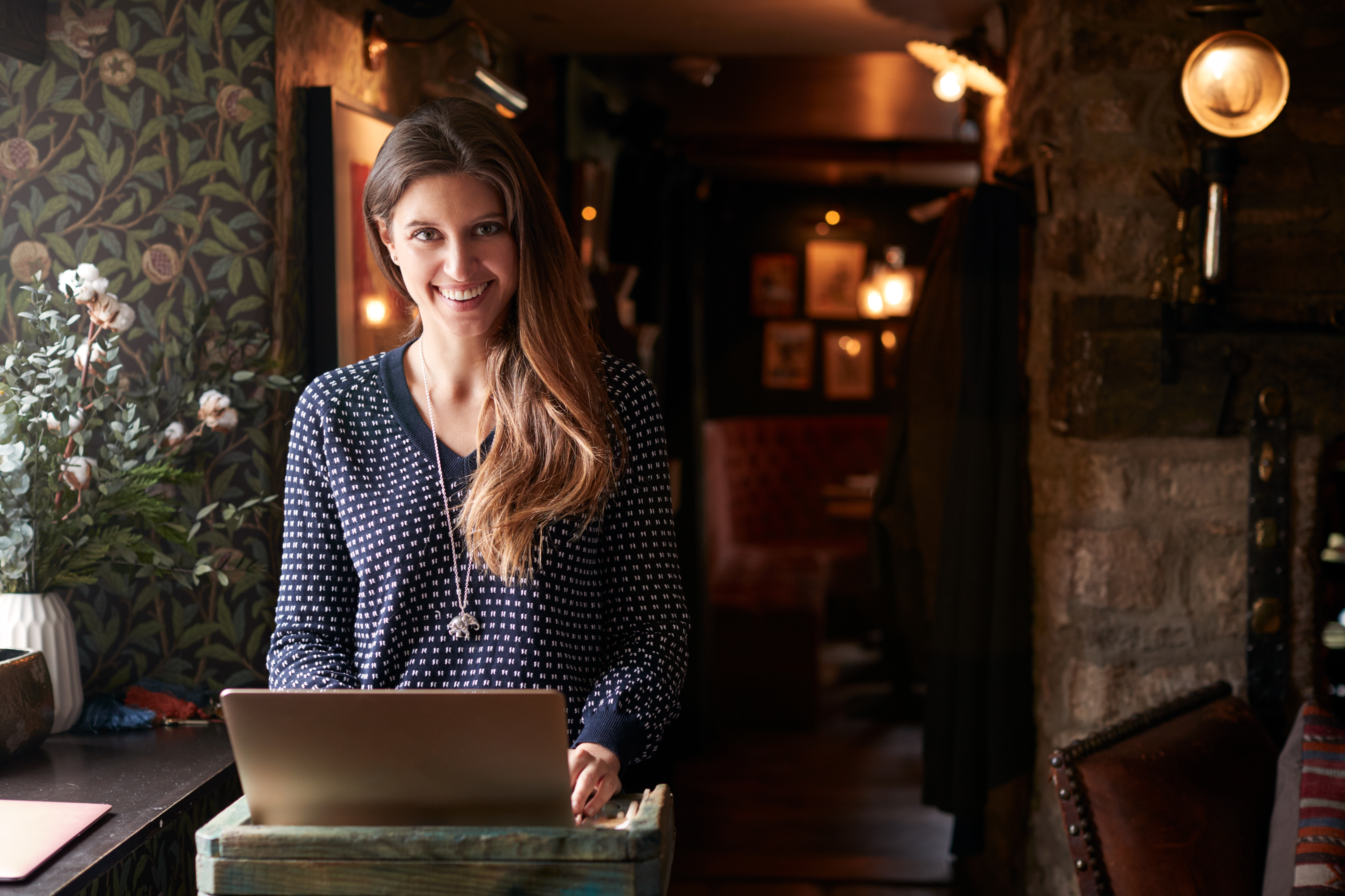 Woman working on laptop at a hotel check-in desk