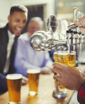 Uomini che prendono delle birre per loro in un pub locale.