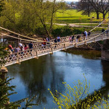 People on a suspension bridge over a river