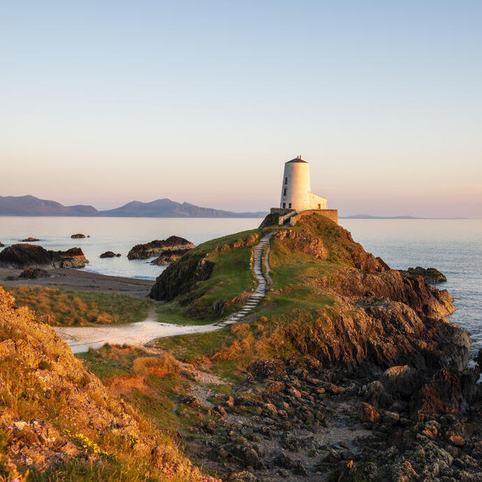 Un sentiero che conduce a un faro su un promontorio roccioso a picco sul mare