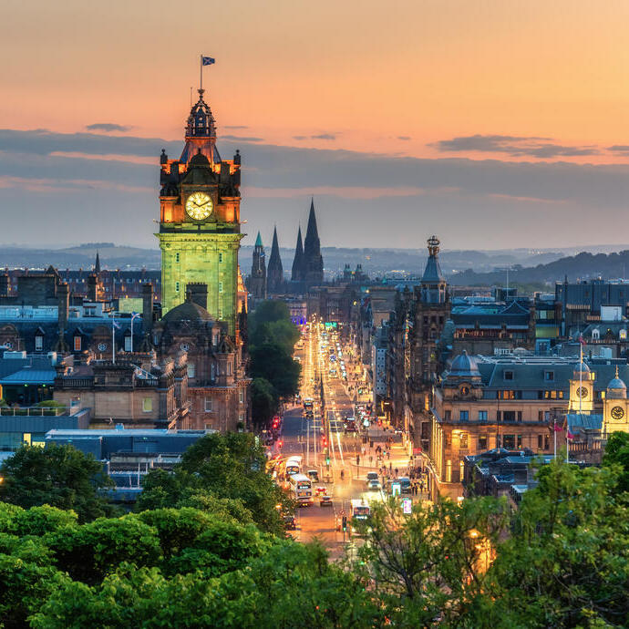 A clock tower at sunset in a busy city