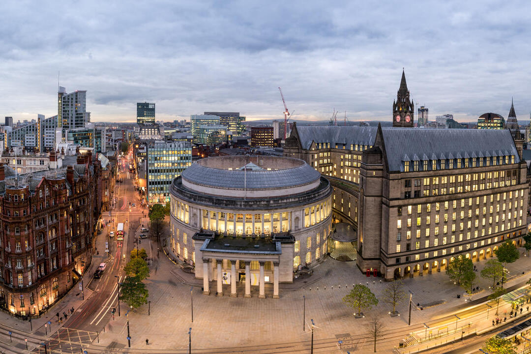 Panorama view over a large city square surrounded by large ornate buildings.