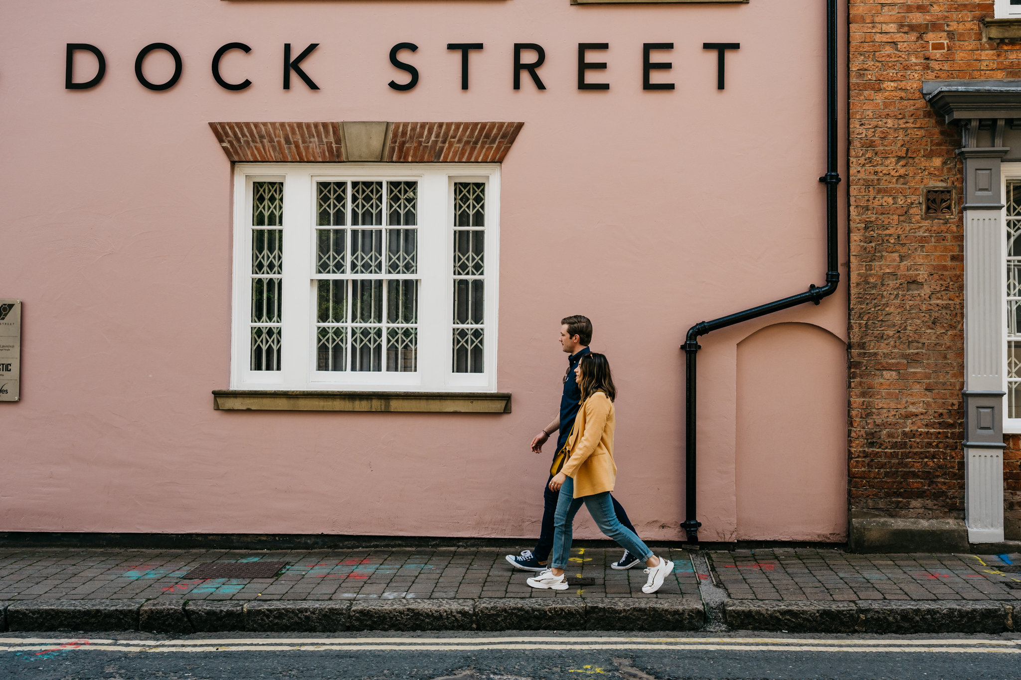Two people walking in front of building
