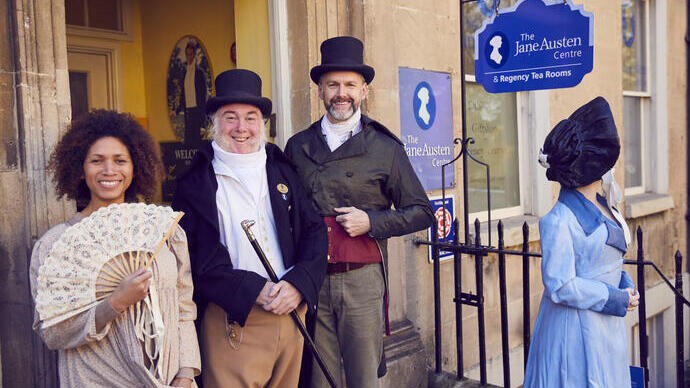 Visitantes y personal con trajes de época fuera del Centro Jane Austen, Bath, Somerset, Inglaterra.