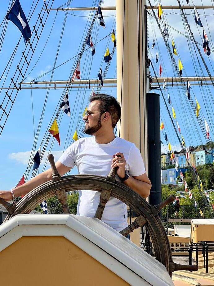 Un uomo in piedi al timone di una nave nel porto di Bristol
