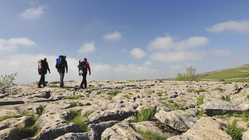 Persone che camminano sulle rocce calcaree sopra le scogliere