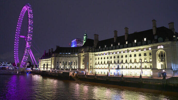 An evening view of a large white building next to a river