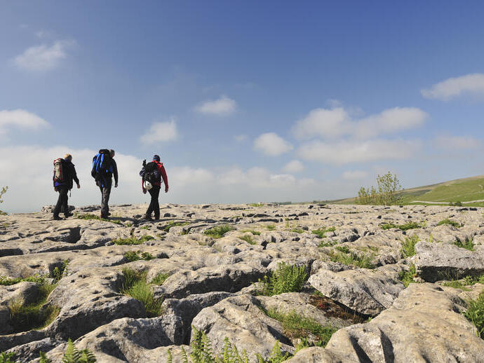 People walking on the limestone rocks above the cliffs