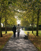 Dos mujeres caminando por un sendero bordeado de árboles en Rowntree Park, York.