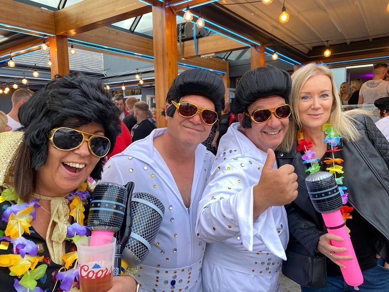Deux imitateurs d'Elvis posant avec des spectateurs lors du festival Elvis à Porthcawl, au Pays de Galles