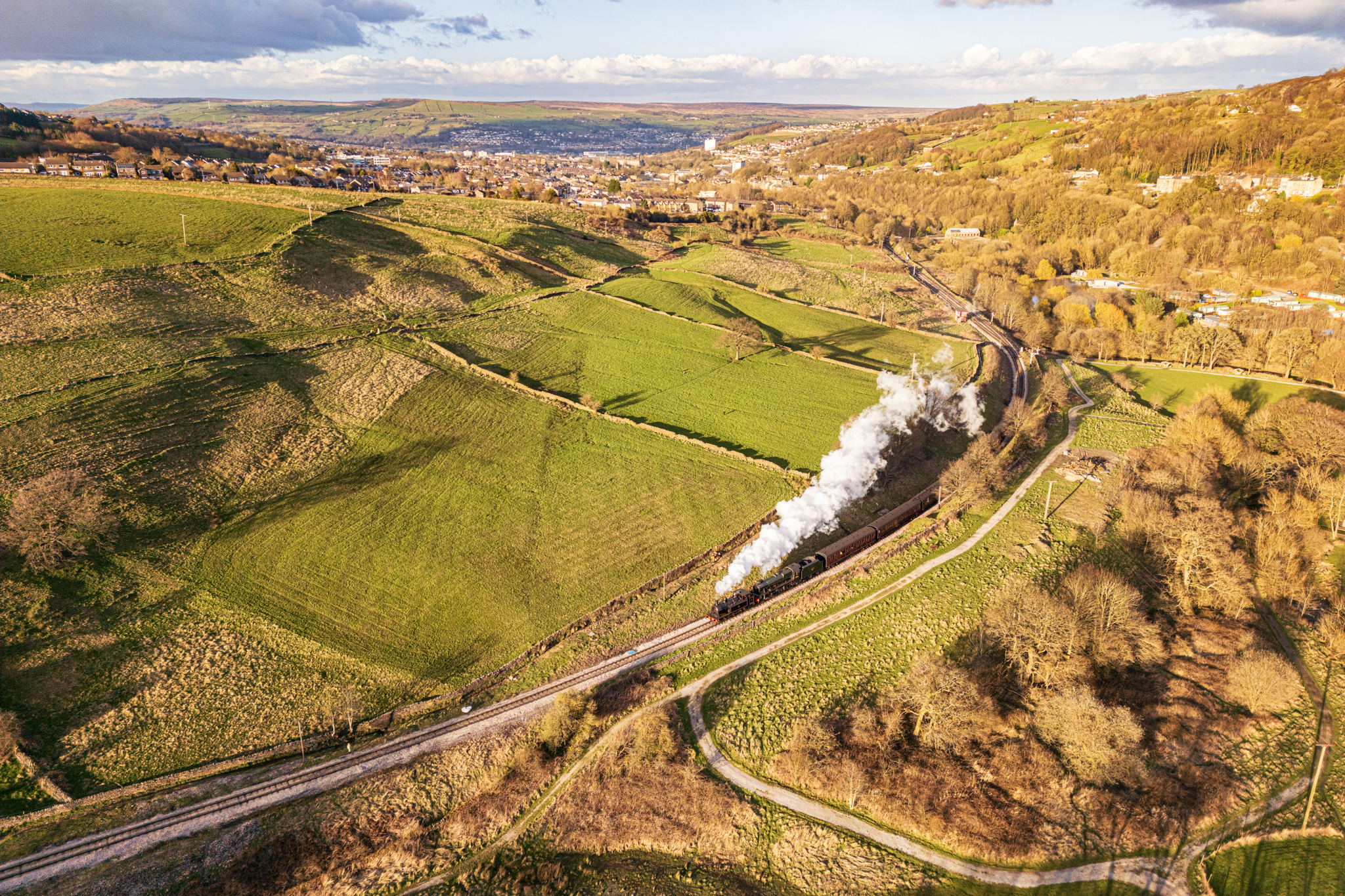Steam train travelling along tracks in the countryside