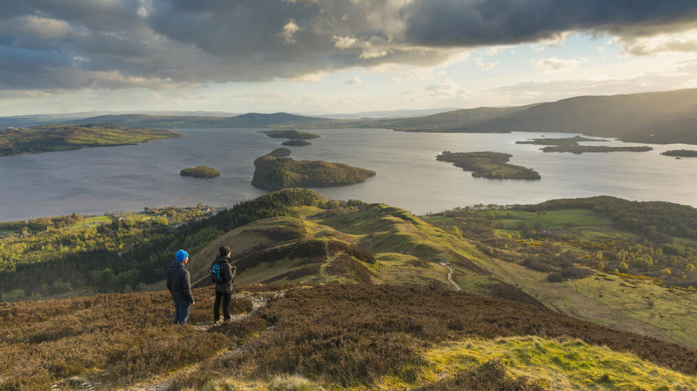 Excursionistas contemplando las vistas del lago Lomond desde Conic Hill, parte de la ruta West Highland Way