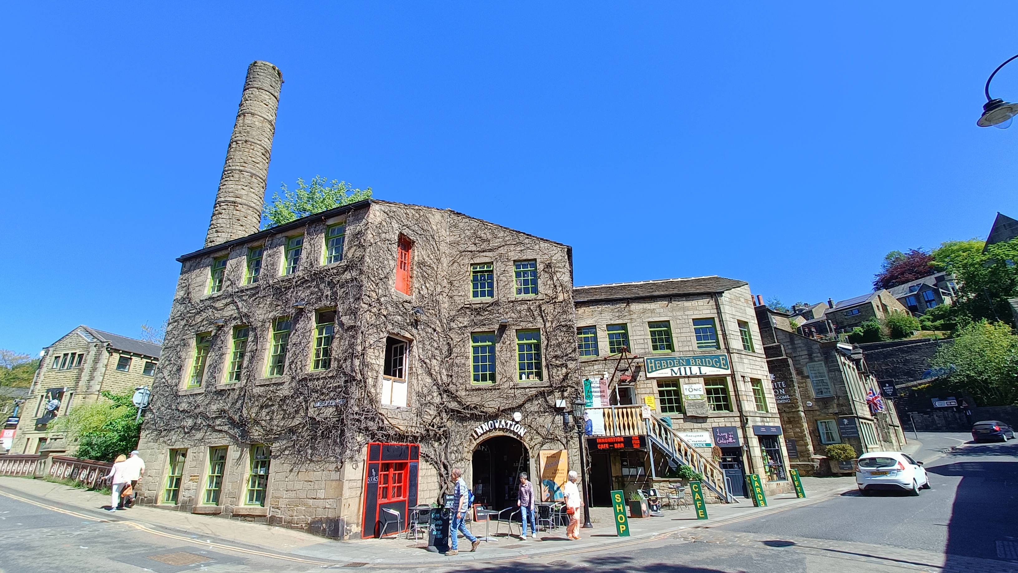 A village mill with passing pedestrians in the centre of an historic country village
