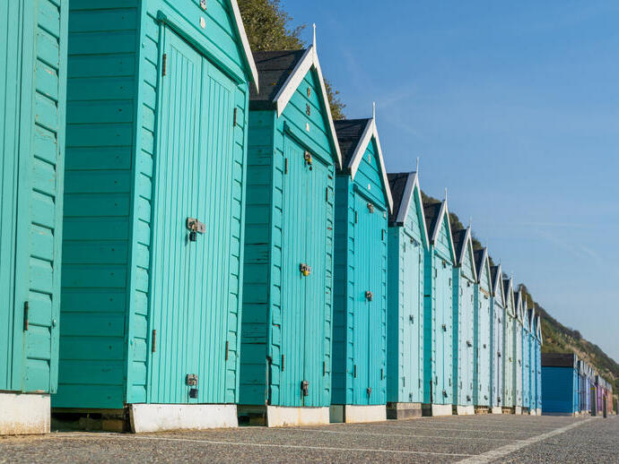 Colourful beach huts in a line.
