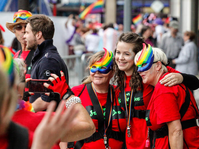 Mujeres con máscaras arcoíris celebrando el festival del Orgullo.