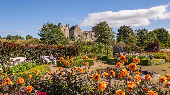 Two female friends walking through a formal garden