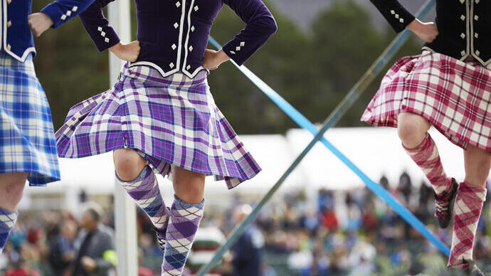 Trois filles en kilt dansant une danse écossaise sur scène