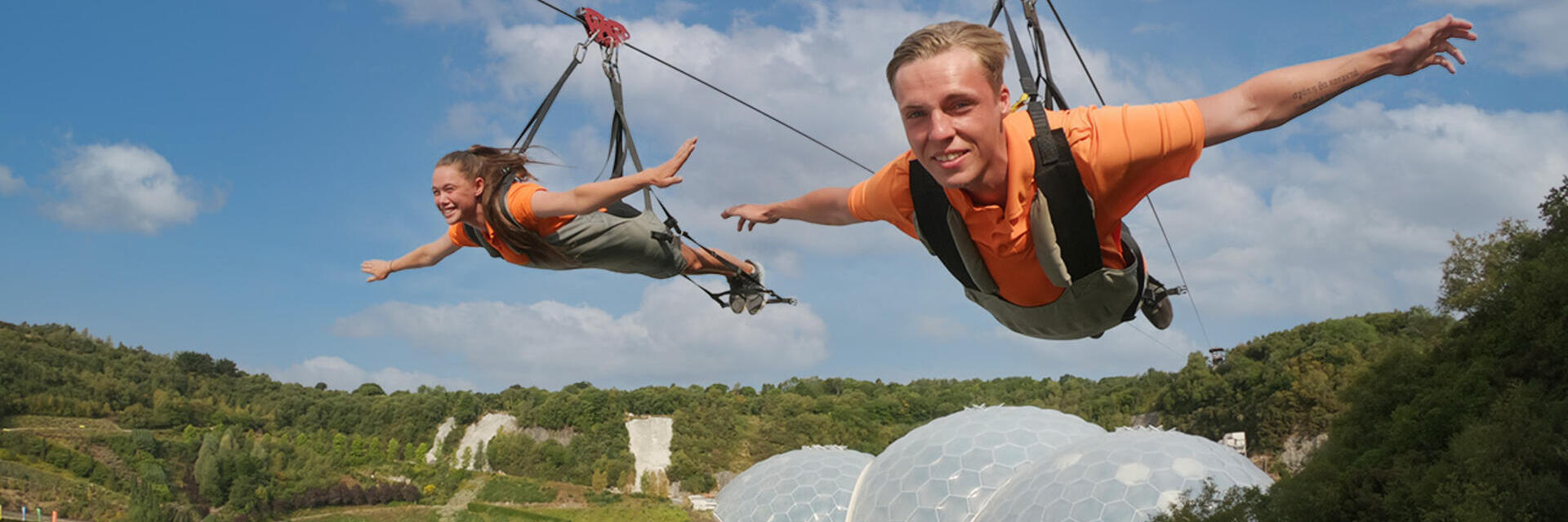 Dos amigos disfrutando de una experiencia de tirolina.