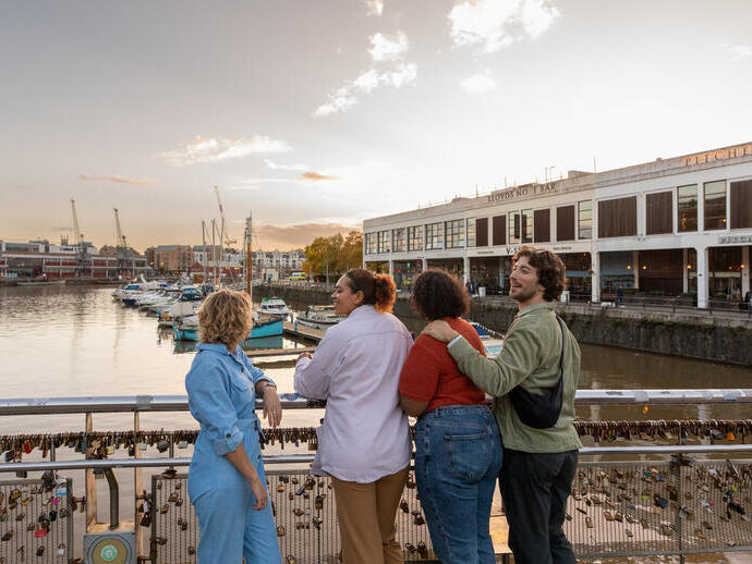 Friends walking over a waterfront bridge.
