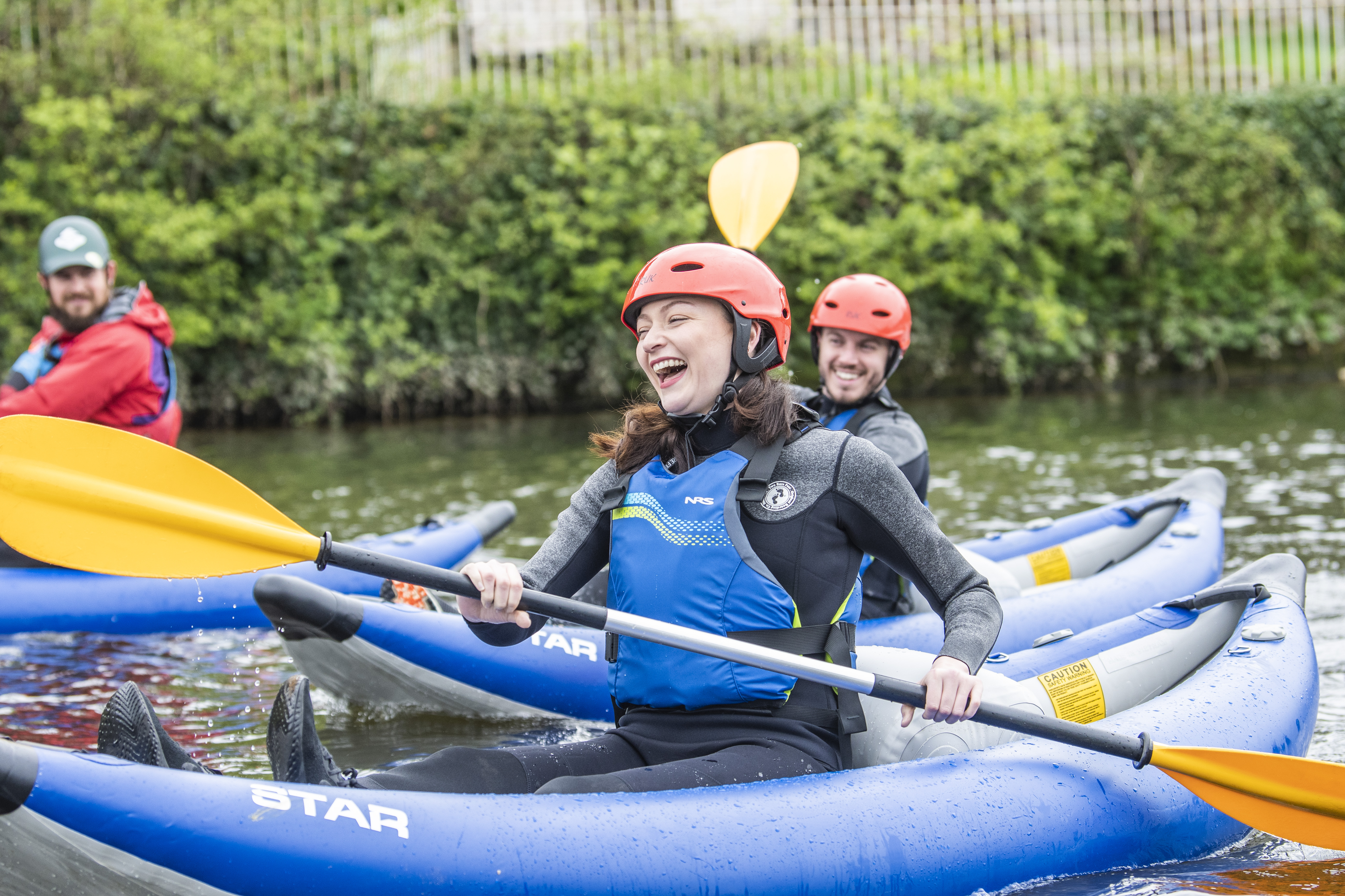 Des gens souriant et riant pendant une descente en kayak sur une rivière à Chester