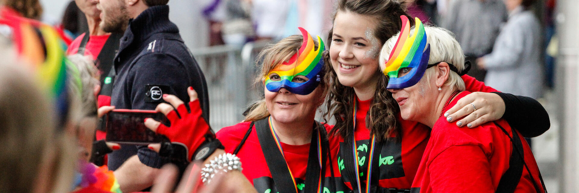 Mujeres con máscaras arcoíris celebrando el festival del Orgullo.
