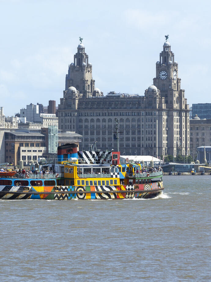 A view to a ferry on a river in front of an iconic building