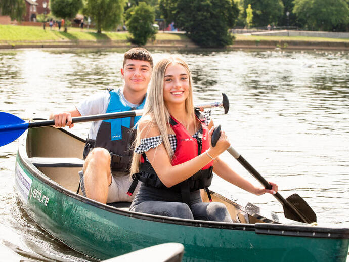 Ein Mann und eine Frau, die mit einem Boot auf einem Fluss paddeln