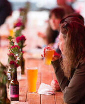 Persone sedute all'aperto a un tavolo che bevono birra