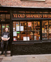 Un hombre de pie frente a una tienda