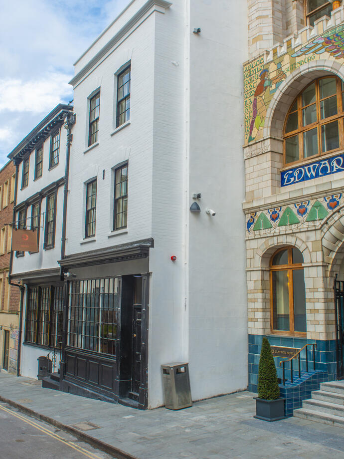 Street view with ornate building facade on a side and a church in the background