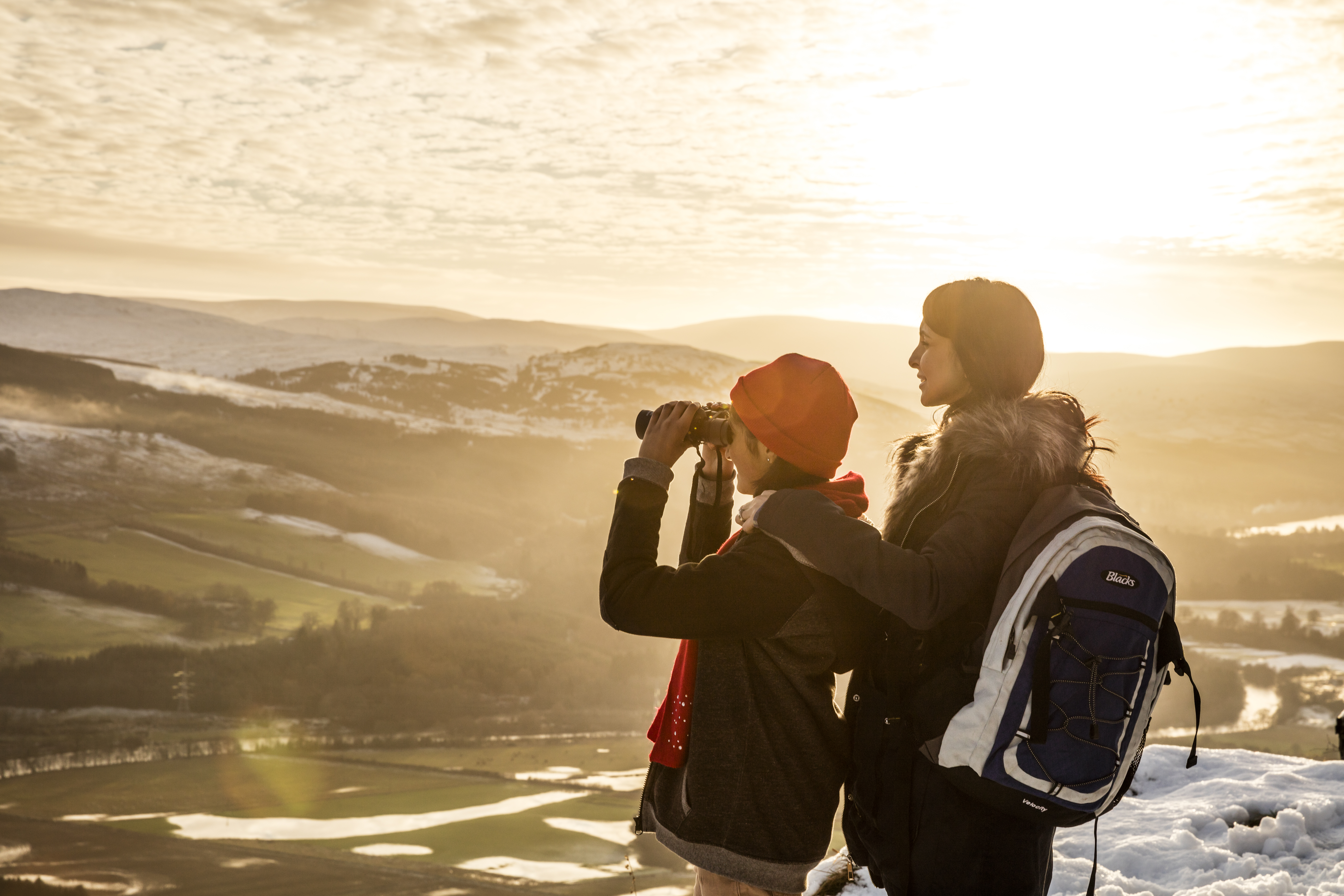 Frau und Teenager in einer winterlichen Landschaft, die die Aussicht betrachten