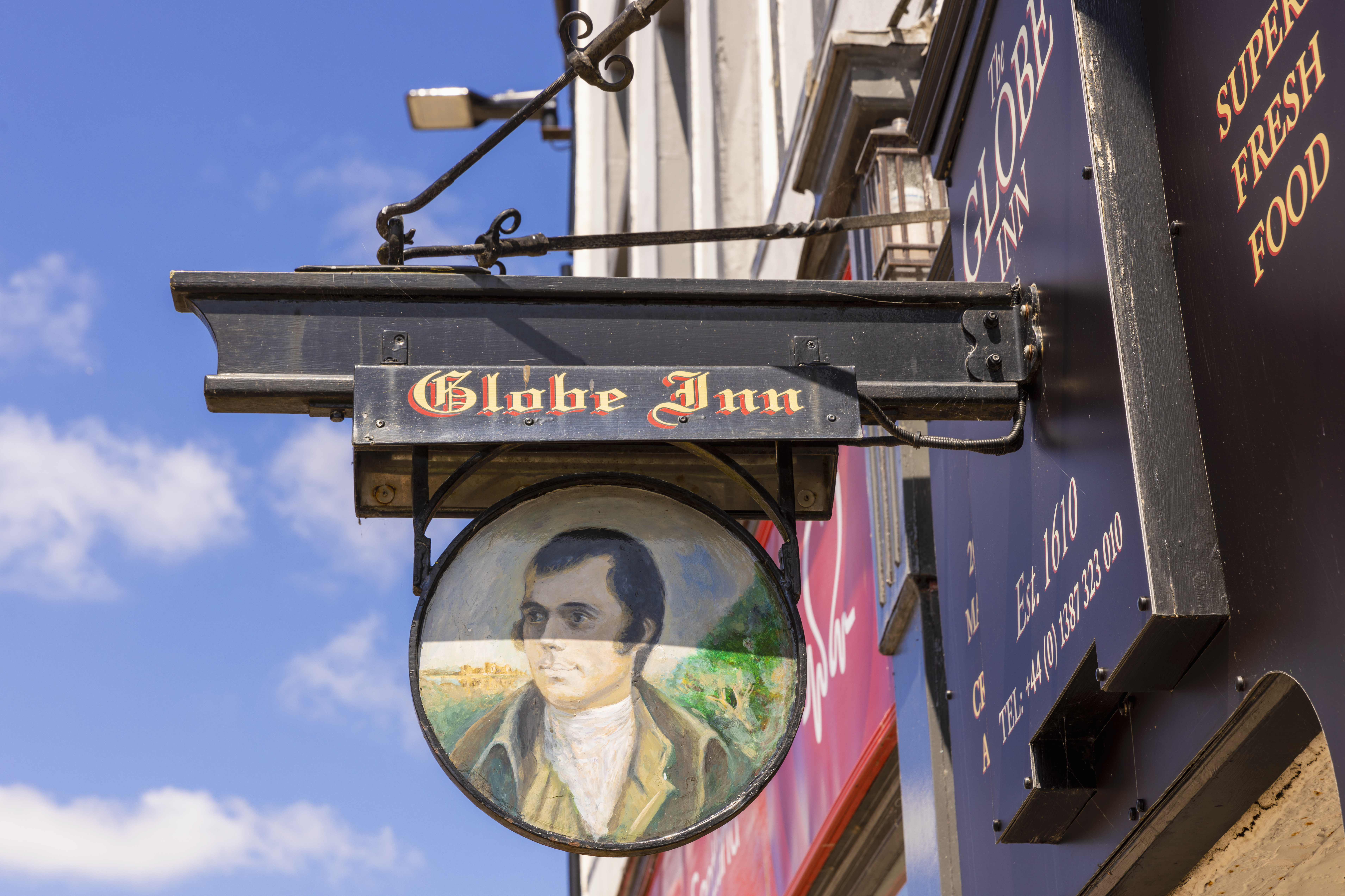 Un letrero de un pub tradicional británico que dice «Globe Inn», con el retrato de un hombre.