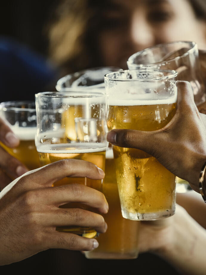 Toma de manos chocando vasos de cerveza