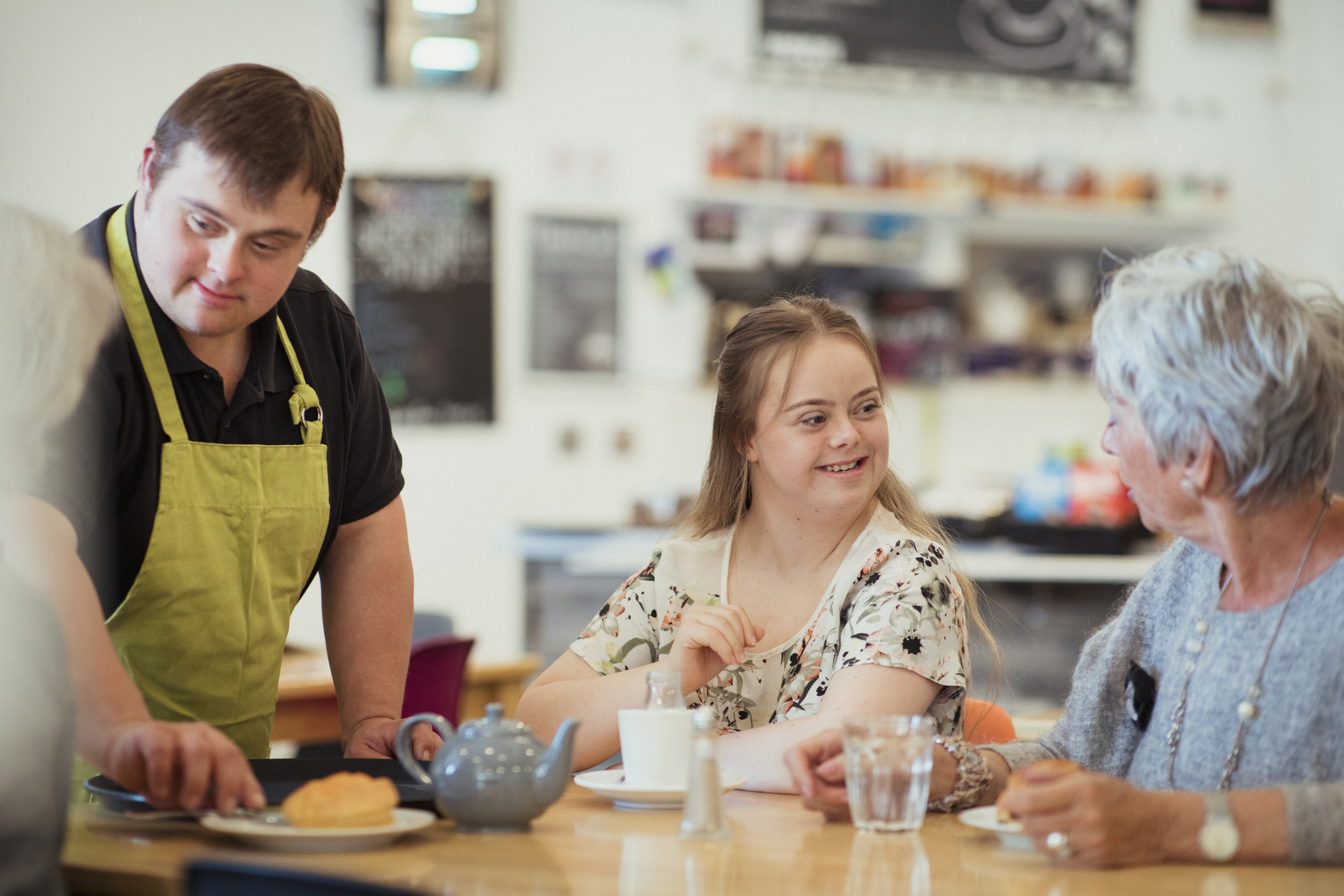 A person with Down's Syndrome serving customers in the cafe