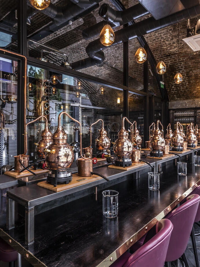 A row of mini gin distilleries set up for tasting sessions at Manchester Gin