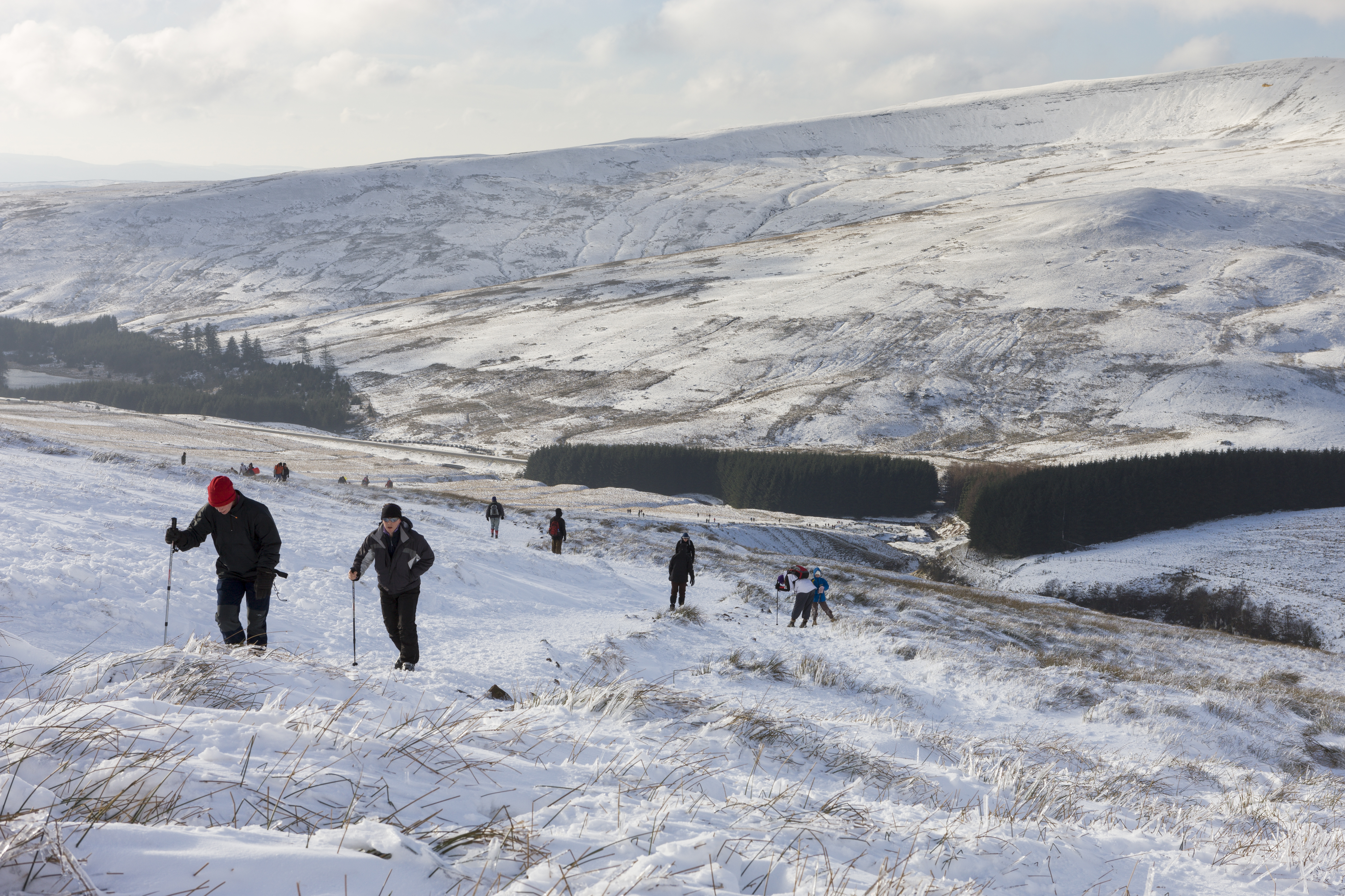Un gruppo di escursionisti, con bastoncini da trekking, nella neve alta