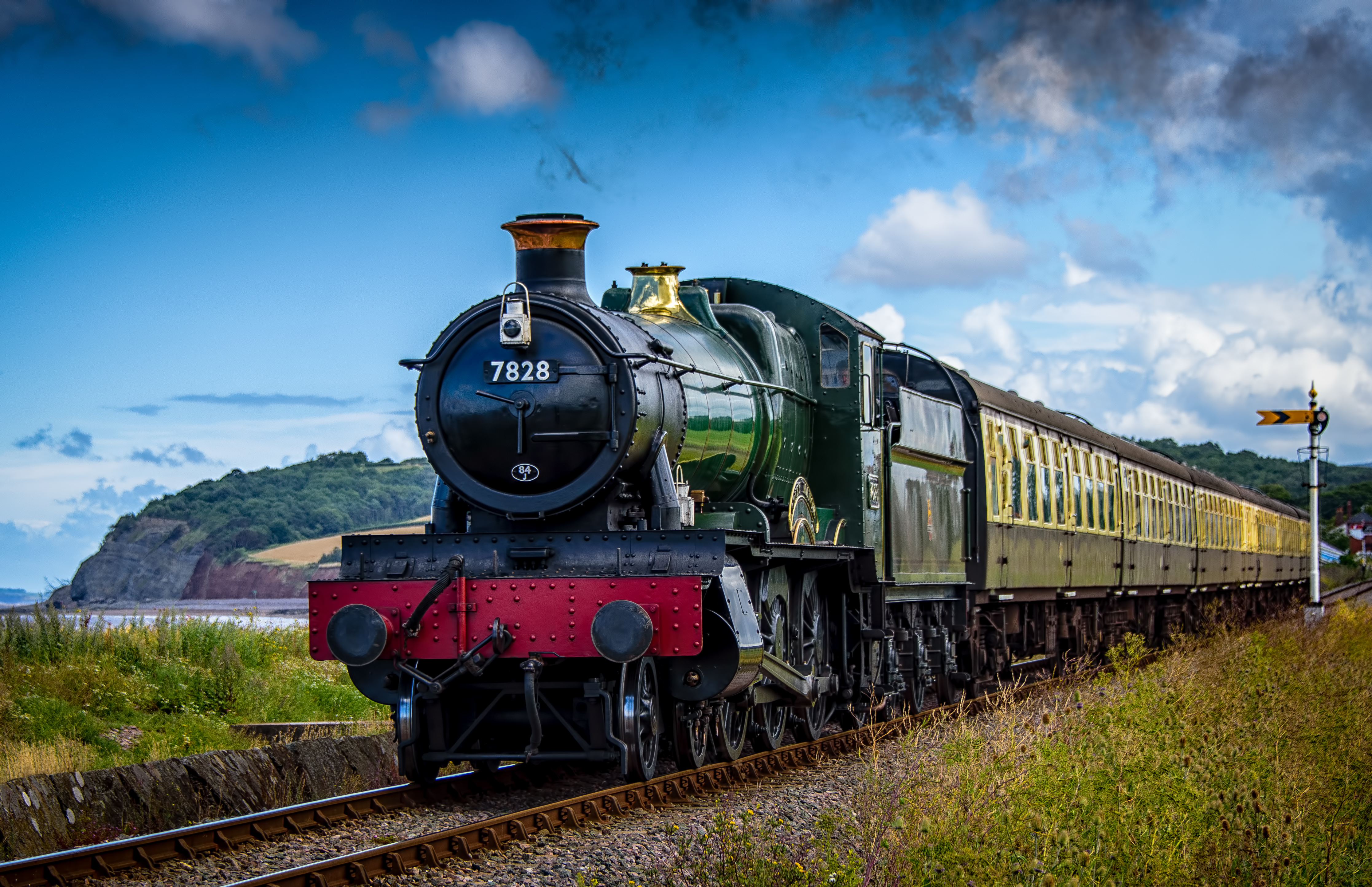 A steam train driving along the coast