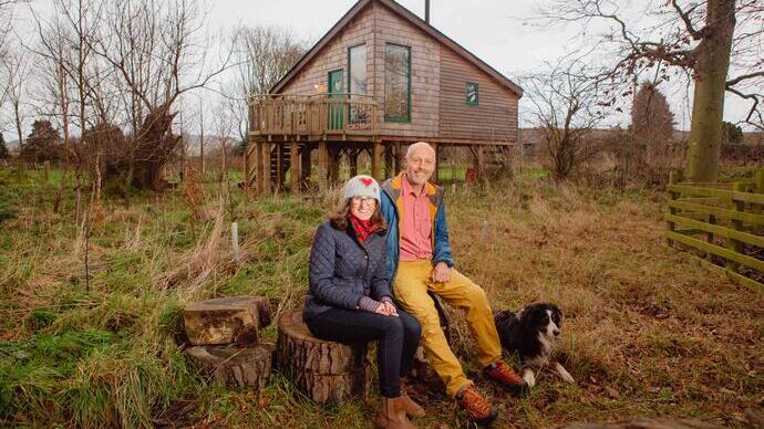 Man and woman sitting in front of cottage