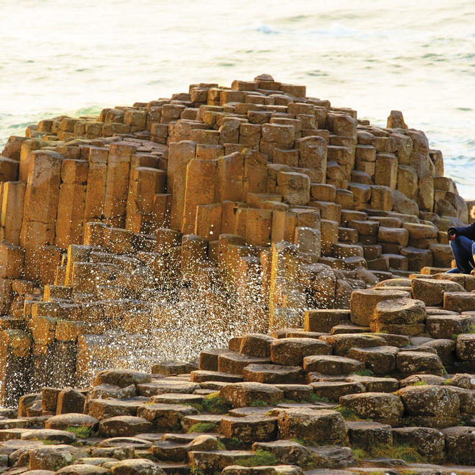 Mann und Kind sitzen auf Felsformationen am Meer