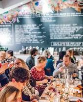 A group of people eating food at a table in Pocos Tapas Bar, Bristol