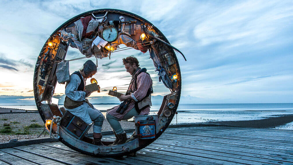 Un homme et une femme assis dans une grande roue décorée pendant un spectacle