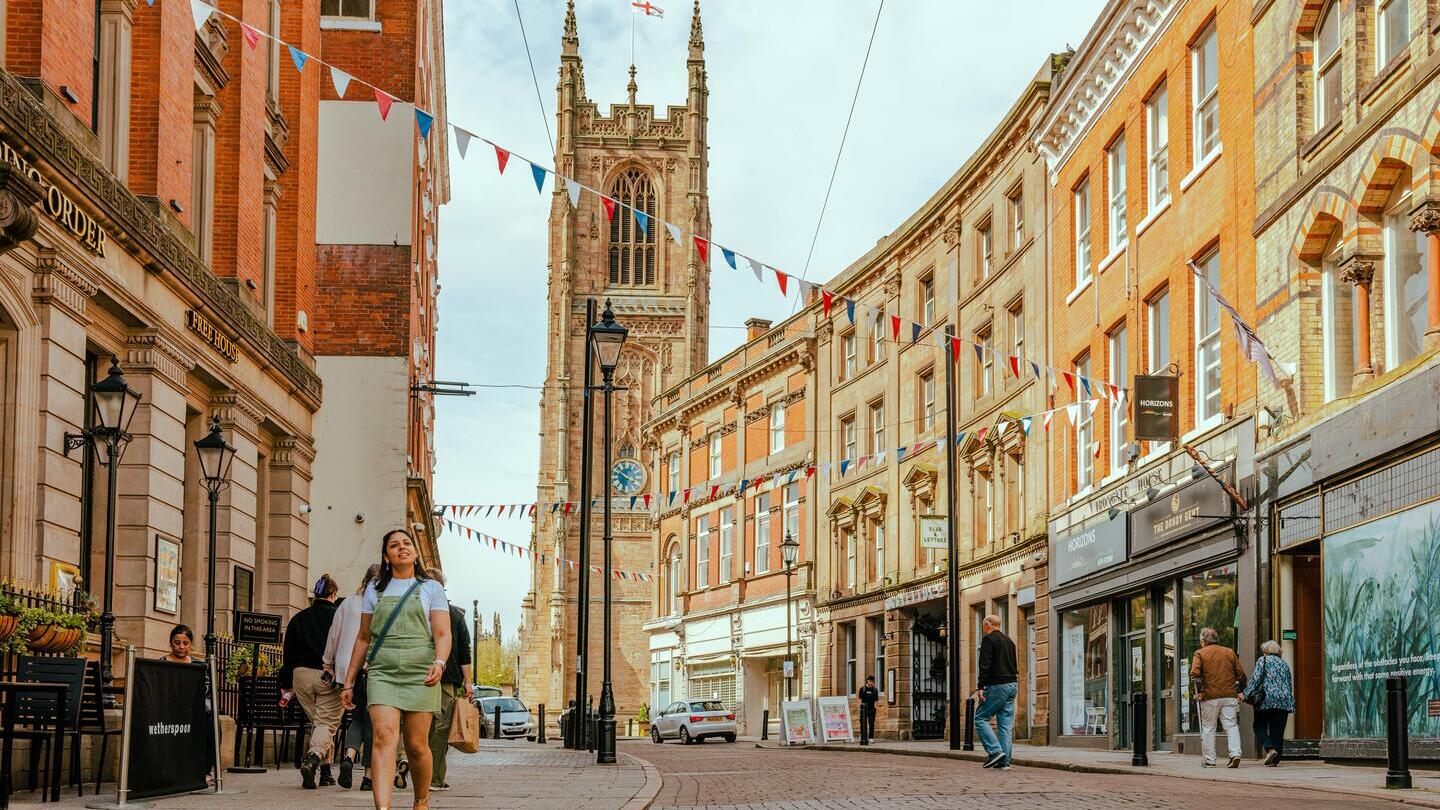 Persone che camminano lungo una strada con una cattedrale