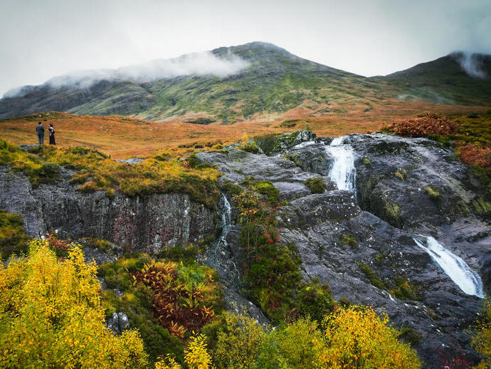Vue d'une chaîne de montagnes en automne, près d'une cascade.