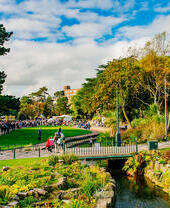 Personas paseando por un parque en un día soleado.