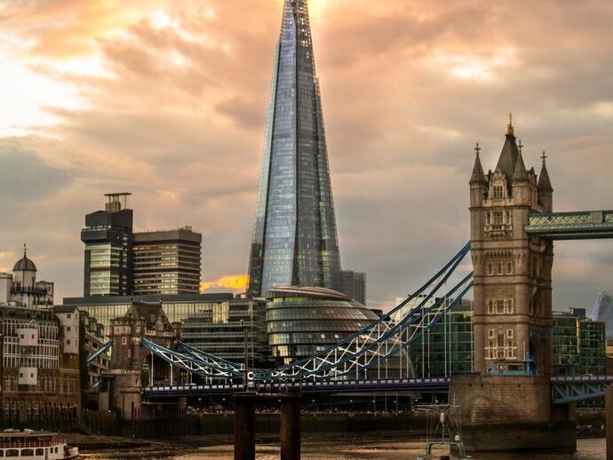 Modern and traditional buildings and bridge looking across a river with a boat in the foreground